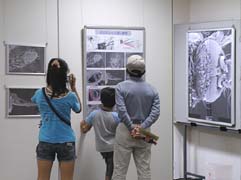 電子顕微鏡展示を見つめる家族